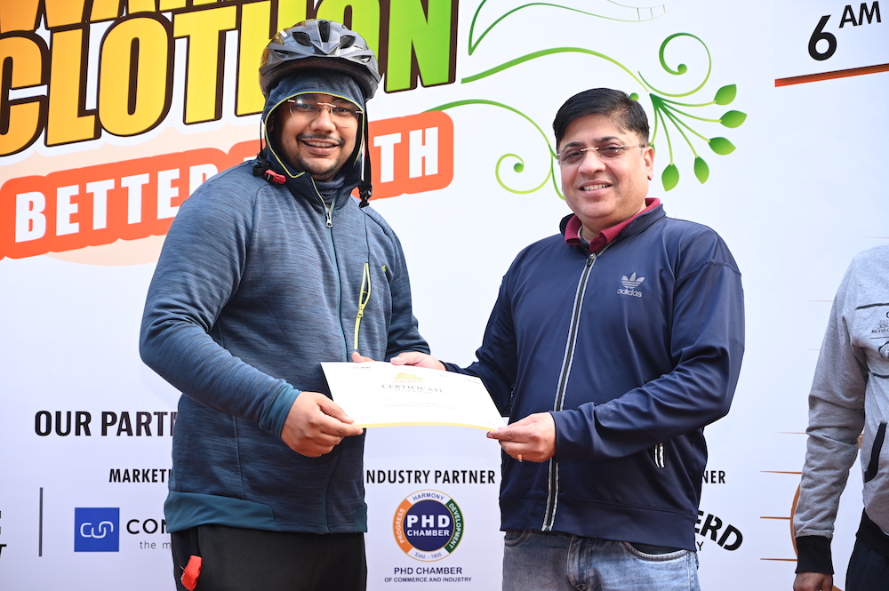 Dr. Prashant Sanwal presenting a certificate to the participant in dwarka cyclothon